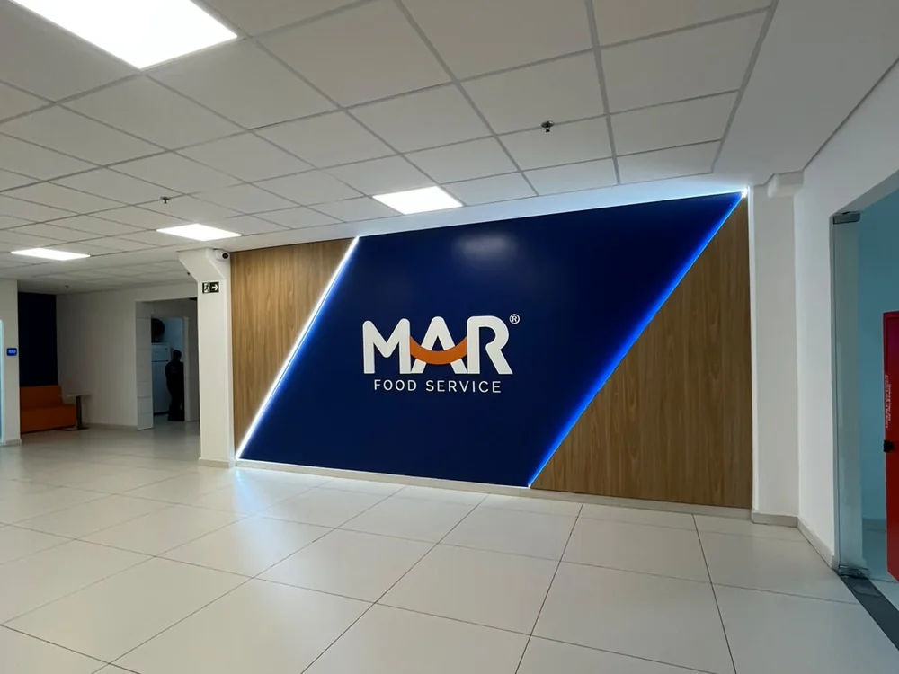 Recepção da MAR Food Service com o logo da empresa na parede
